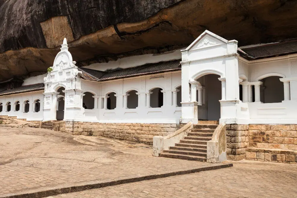 Golden Buddha figures lining the interior wall of a Dambulla cave shrine