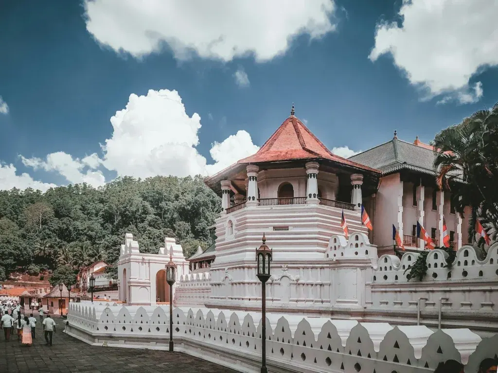 The Temple of the Sacred Tooth Relic in Kandy, its white walls reflected in the lake
