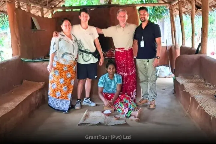 Two guests and their guide standing on rocks beside a jungle river