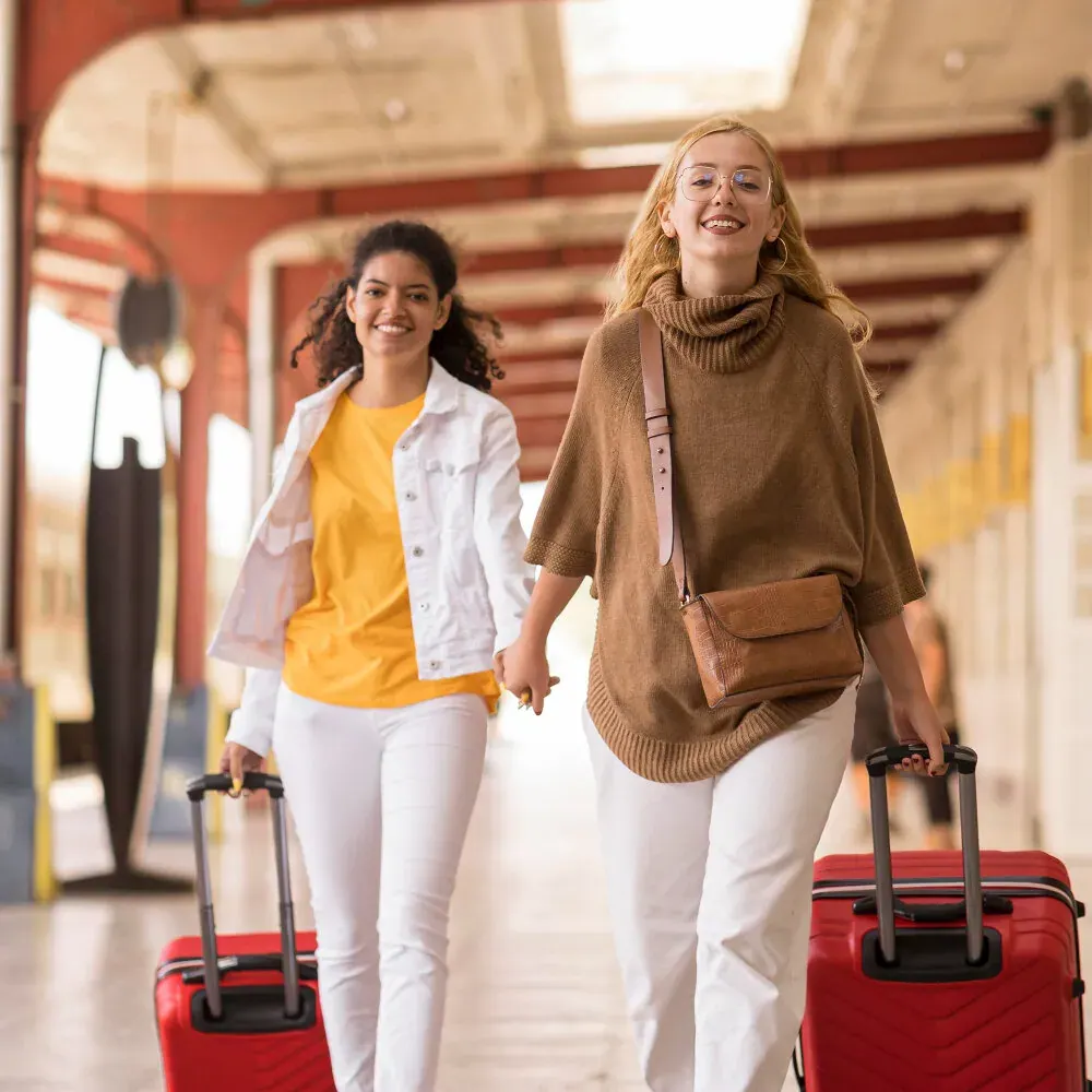 Two travellers walking with their luggage at the start of a trip